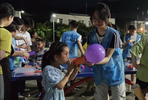 志愿者和小朋友一起体验“火箭”升空。bat365官方官网物理与电子工程学院供图