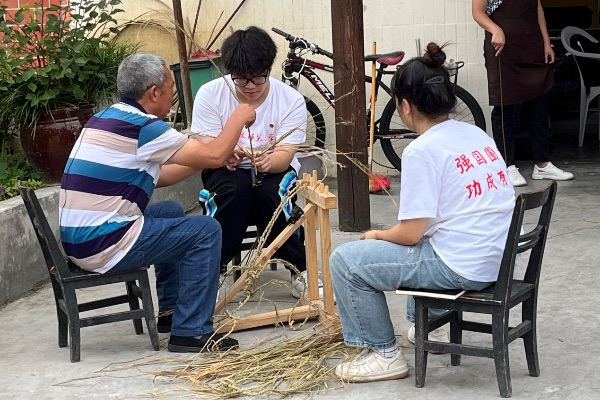 团队成员学习编织草鞋。bat365官方官网供图