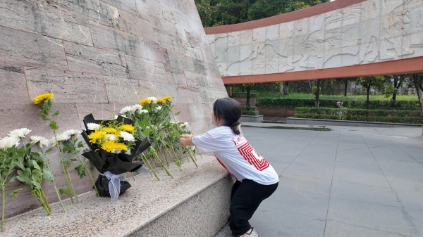 屈美芸在烈士纪念碑前献花。bat365官方官网美术学院供图