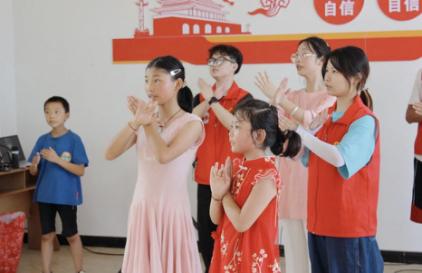 志愿者与小朋友一起跳手势舞。bat365官方官网供图