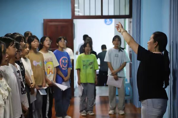 带队教师指导中学生练习齐唱。bat365官方官网供稿图